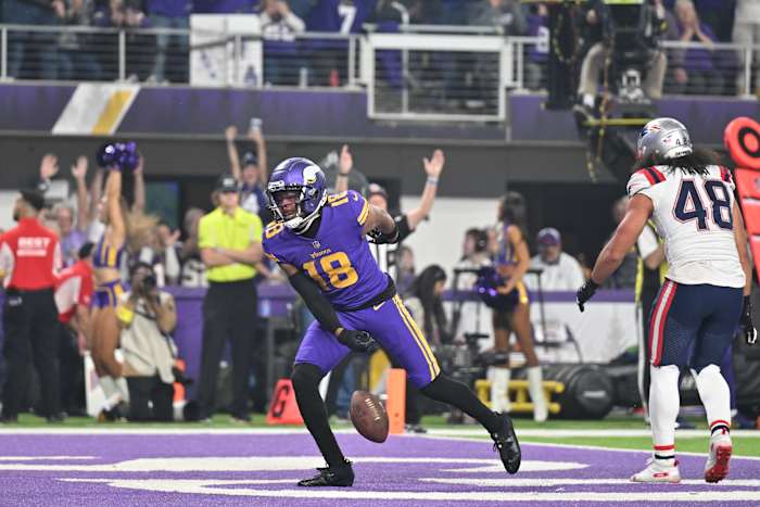 Nov 24, 2022; Minneapolis, Minnesota, USA; Minnesota Vikings wide receiver Justin Jefferson (18) reacts after a touchdown as New England Patriots linebacker Jahlani Tavai (48) looks on during the first quarter at U.S. Bank Stadium.